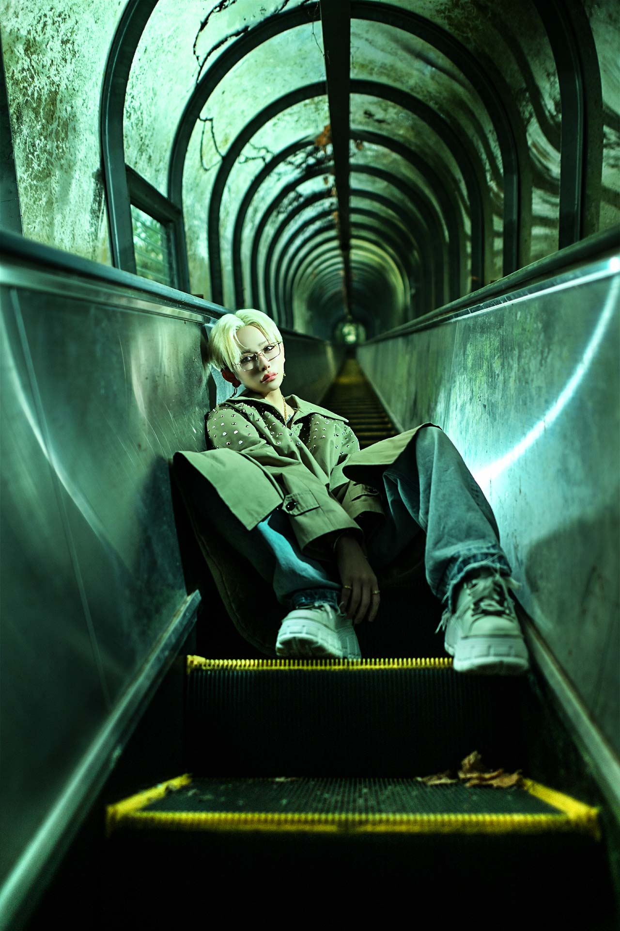 TOP DANDY TOKYO レオナルド・レノピが静岡県の廃墟エスカレーターに深く腰を下ろし、正面を鋭く見つめるホスホスゼングラのポートレート