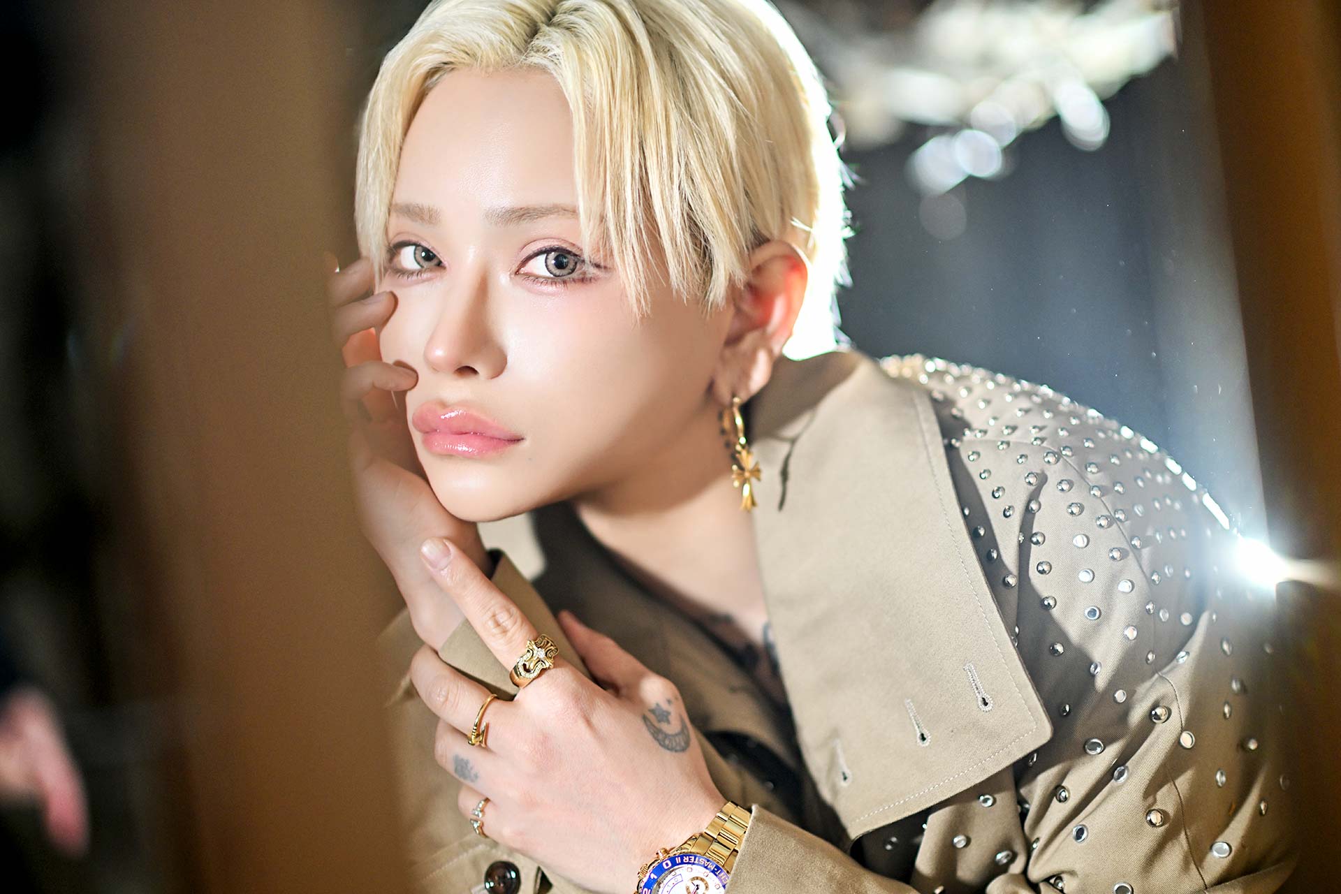 TOP DANDY TOKYO レオナルド・レノピが静岡県の廃墟で頬に手を添え、アクセサリーを輝かせながら見つめるクローズアップのゼングラポートレート