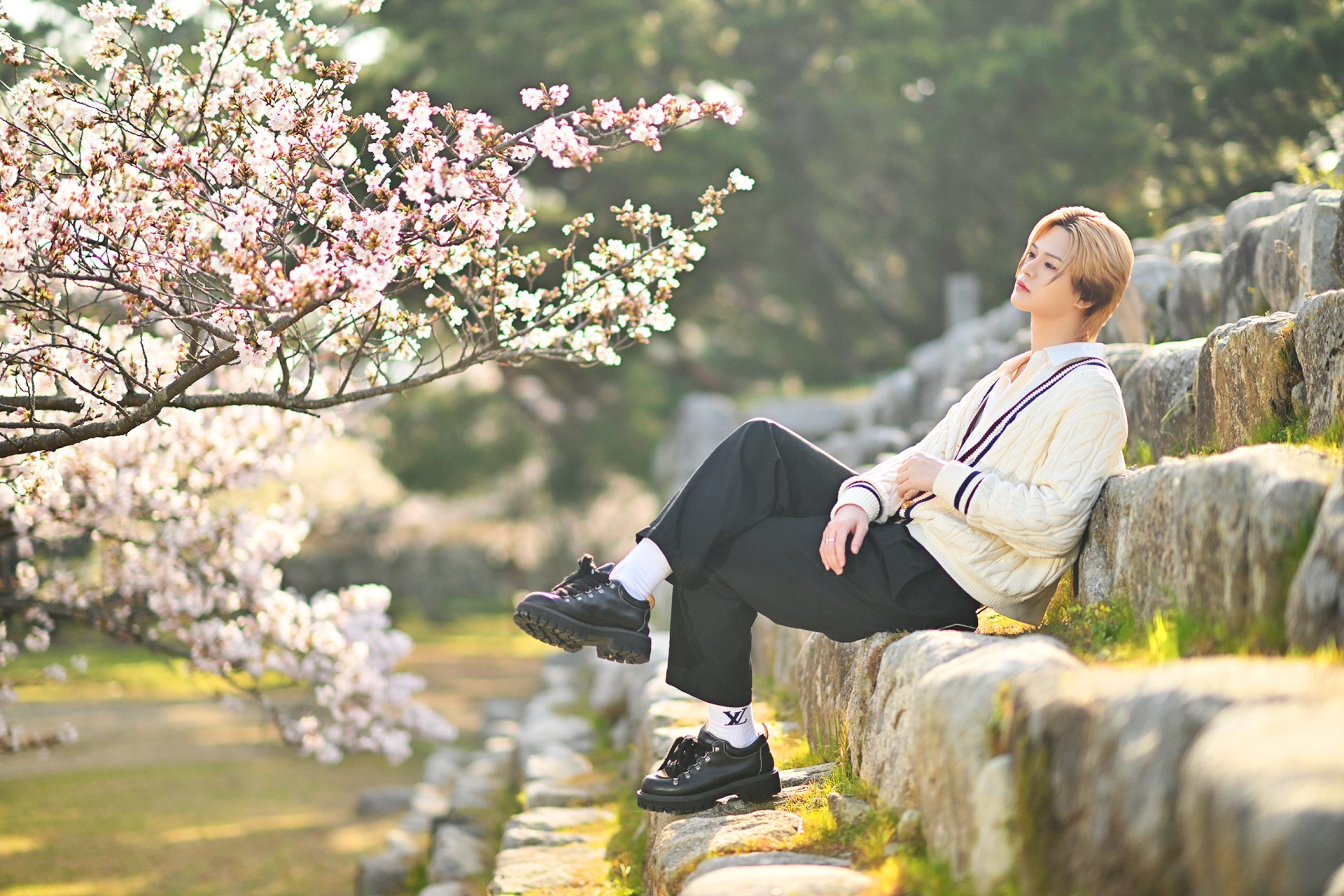 Leo 美月が石垣に腰掛けながら桜並木を眺める自然体ショット