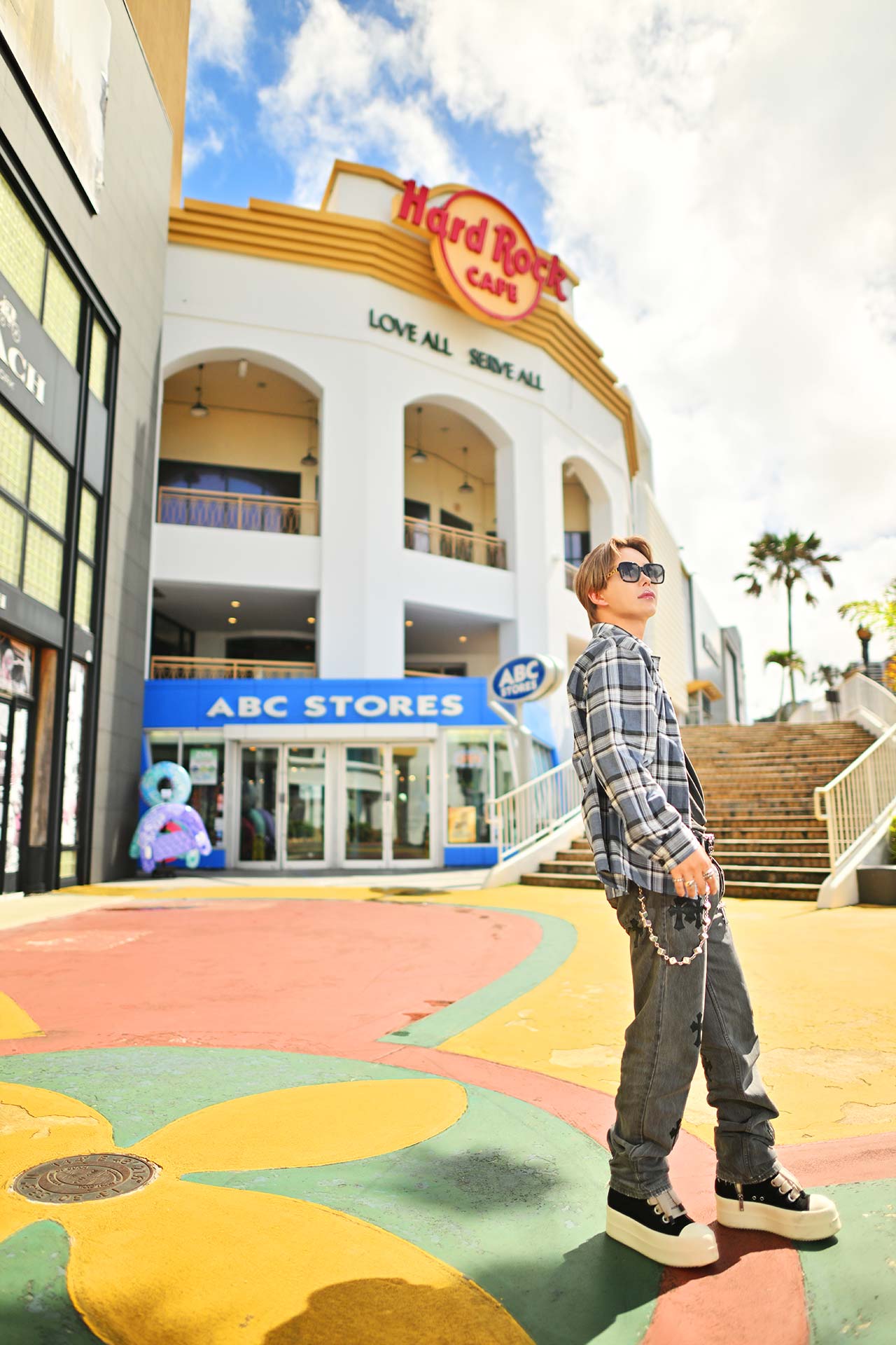 Hard Rock Cafe前で立つ華神疾翔、グアムの街並みとモードファッションが映える海外スナップ