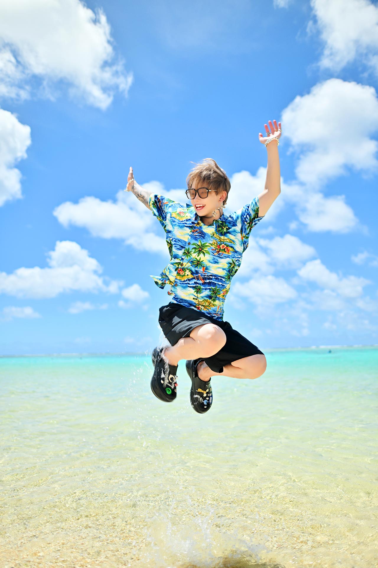 グアムの浅瀬でジャンプする華神疾翔を捉えたダイナミックショット。快晴の空と透明な海が広がる夏感満載のグラビア写真