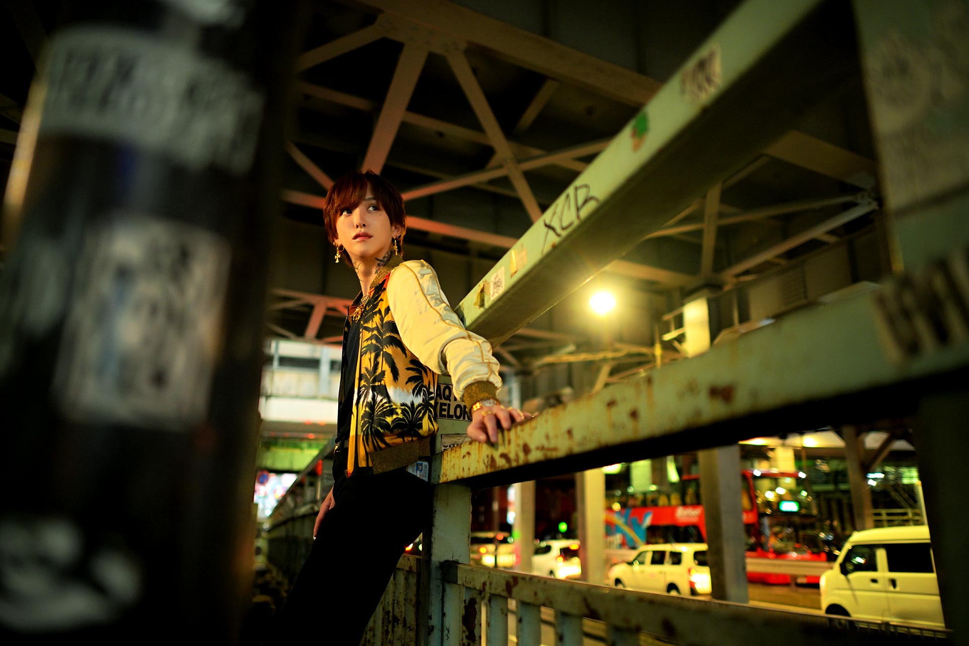 渋谷の高架下で手すりにもたれ夜の街を見つめる天音恋愛